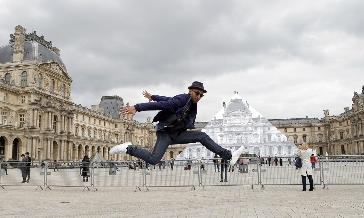 JR poses in front the Louvre Pyramid. Photo: AP 
