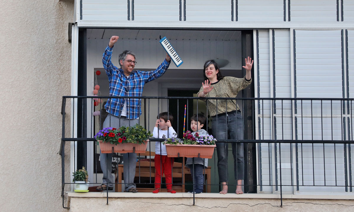 Israelis dance and look on from their balconies as saxophonists play on a roof in Tel Aviv. Photo: EPA