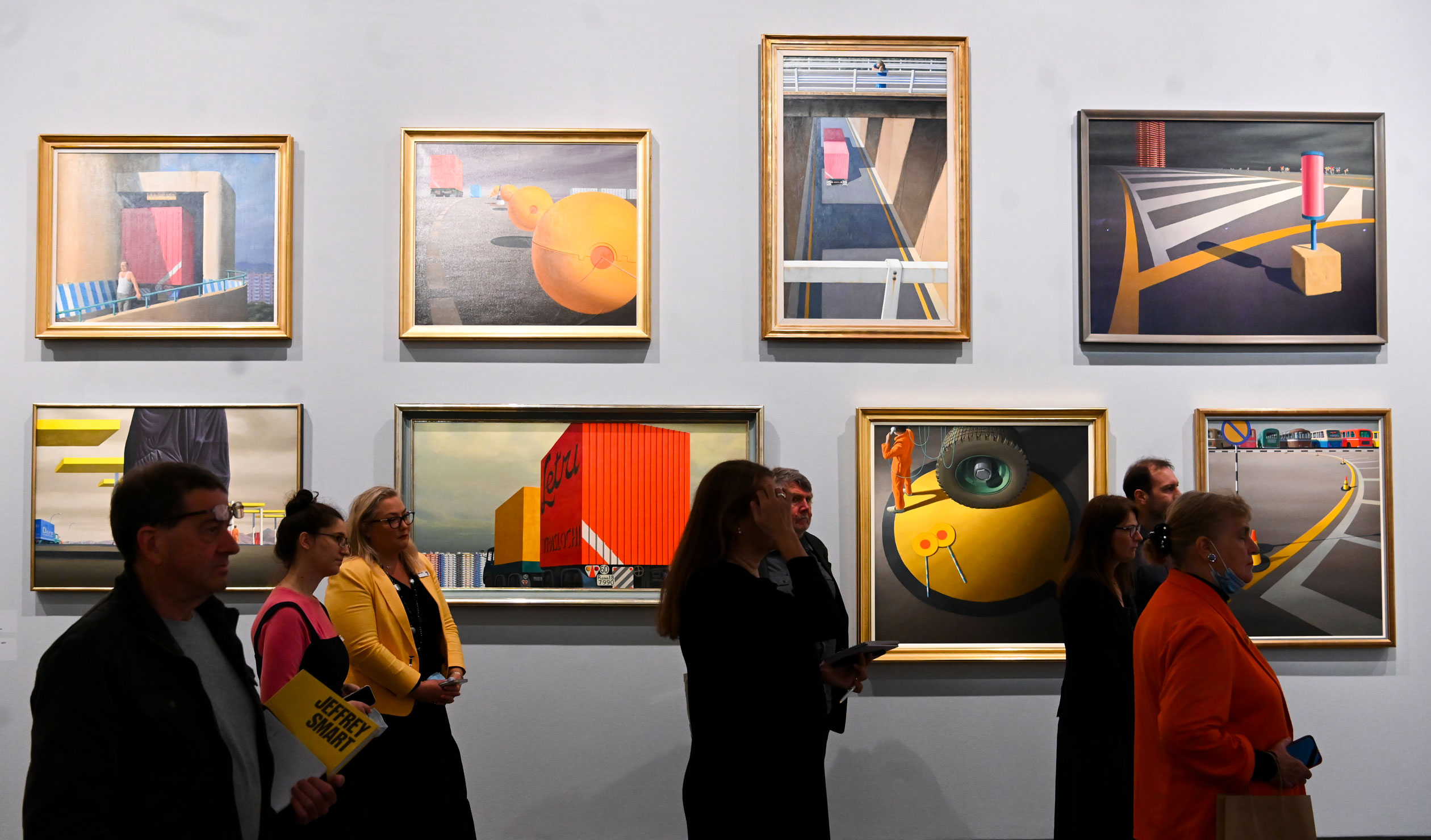 Visitors look at artwork during a media preview of the Jeffrey Smart exhibition at the National Gallery  in Canberra. Photo: Lukas Coch / AAP