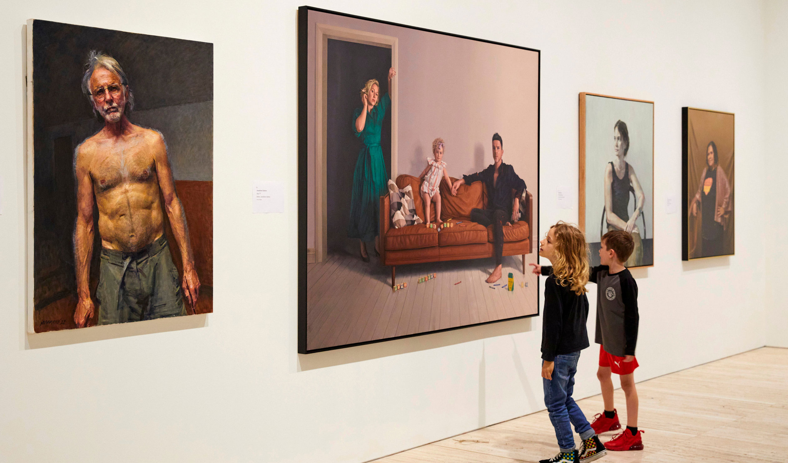 Children view the 2022 Archibald Prize exhibition at the Art Gallery of NSW, including (foreground) Robert Hannaford's self-portrait and (far right) Tsering Hannaford's painting of Sally Scales. Also pictured are portraits by Jonathan Dalton and Keith Burt. Photo:  Felicity Jenkins / ©AGNSW