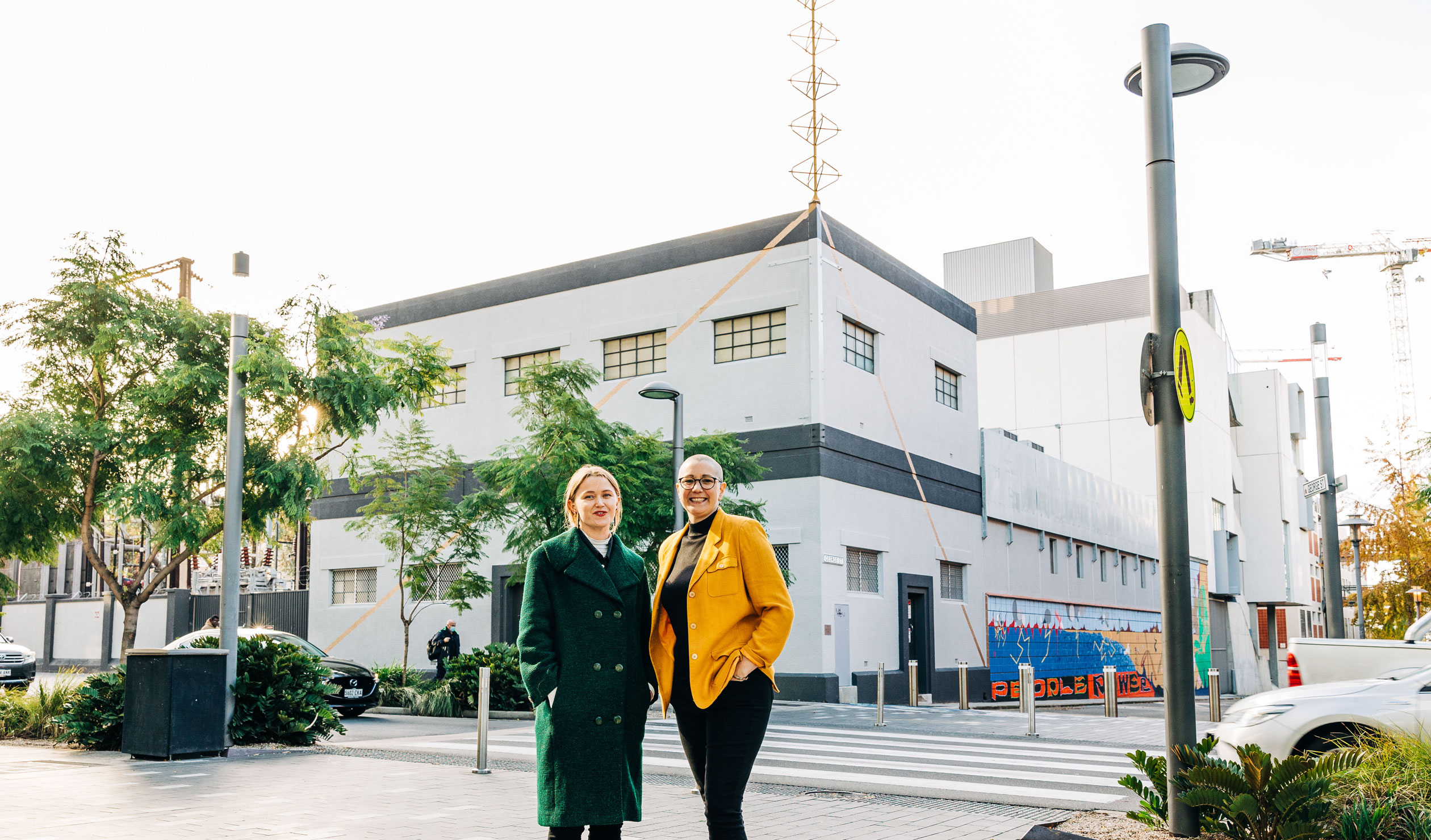 Artists Frances Rogers and Oakey in front of 'Endless Hoist' on the roof of the Hindley Street substation. Photo: Samuel Graves
