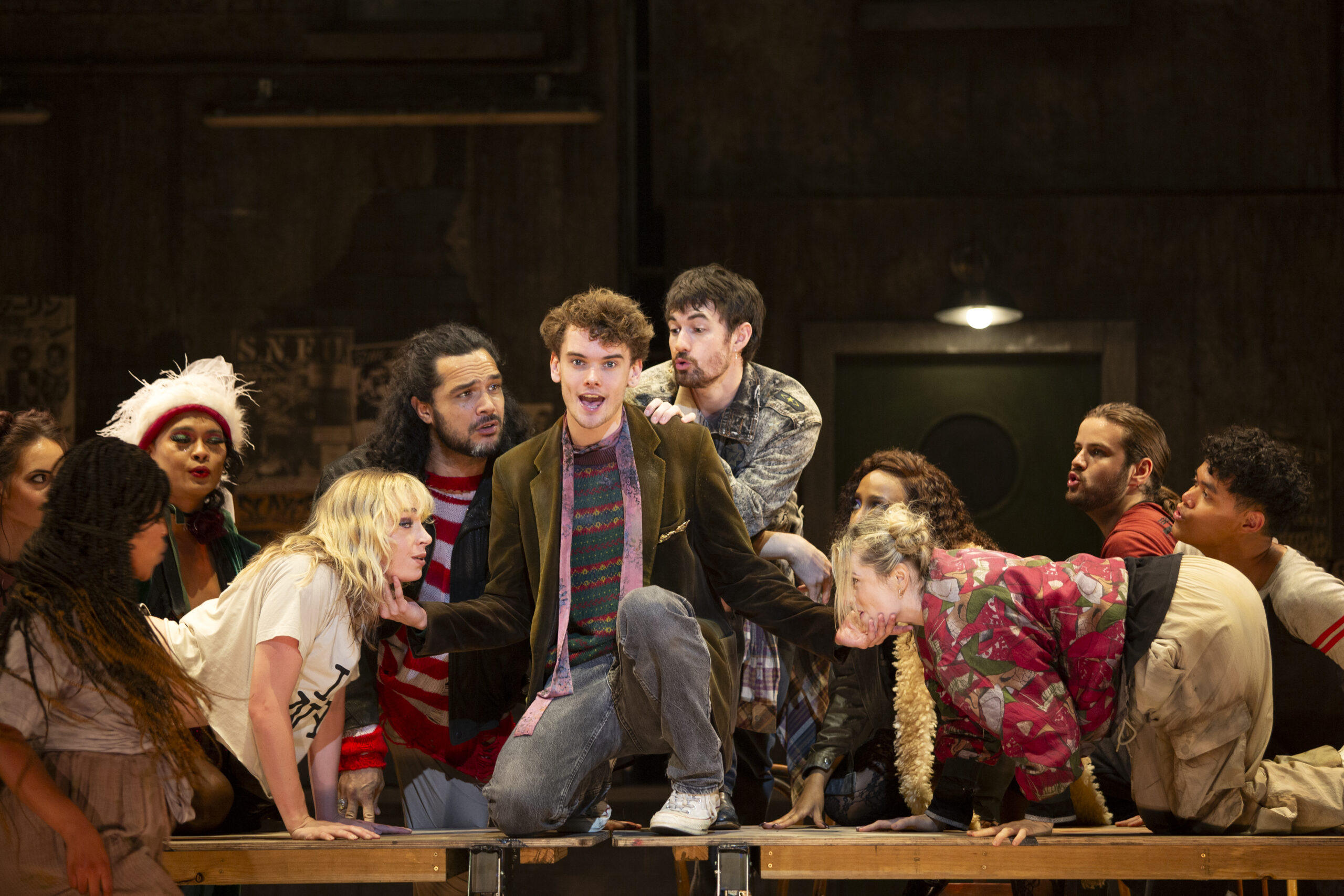 Noah Mullins (centre) who plays the camera-wielding Mark in '90s classic RENT: The Musical, surrounded by fellow cast members. Photo: Pia Johnson