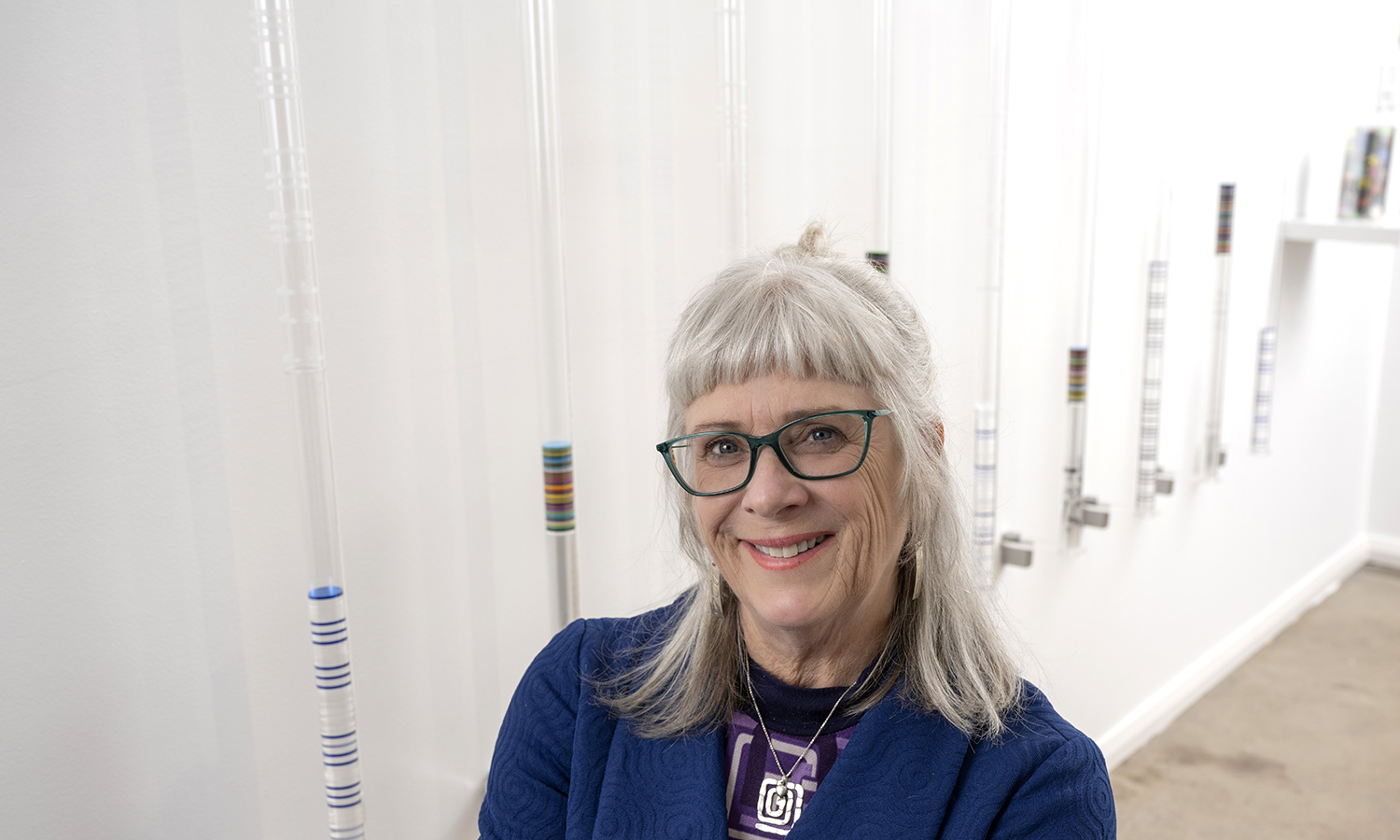 Andrea Przygonski with her work "At the Core", featuring morse code etched into acrylic tubes. Photo: Michael Haines / supplied
